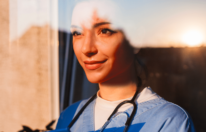 Professionnelle de santé regardant vers l'horizon avec le reflet du soleil
